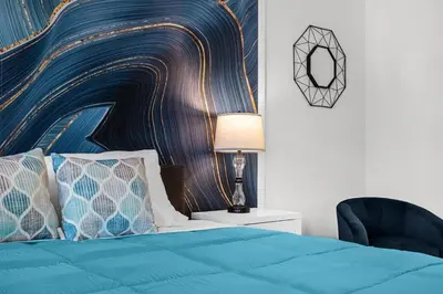 a bedroom with a blue bed and a chair at Super Deal - Brand New Themed 9BR Home near Disney in Kissimmee