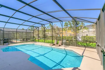 a swimming pool with a retractable roof at Modern 6BR Home - Pool Games BBQ - Near Disney in Kissimmee