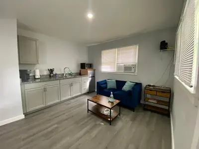 a living room with a blue couch and a kitchen at The Oasis in Sanford