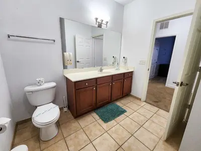 a bathroom with a toilet and a sink and a mirror at Retreat at Secret Lake 10 mins to Disney in Kissimmee