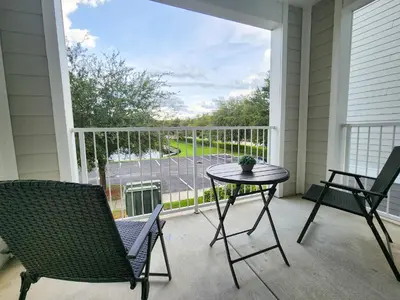 a porch with a table and chairs and a view of a street at Retreat at Secret Lake 10 mins to Disney in Kissimmee