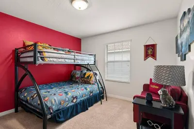 a bedroom with a bunk bed and a red wall at Storey Lake Townhome fun for families at Remy's Retreat in Kissimmee