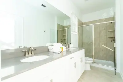 a white bathroom with a sink and a toilet at Super Luxury Modern Home, Prime Location in Kissimmee