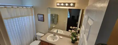 a bathroom with a sink and a toilet and a mirror at Emerald Island Diamond on the Island in Kissimmee