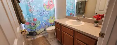 a bathroom with a sink and a toilet with a shower curtain at Emerald Island Diamond on the Island in Kissimmee