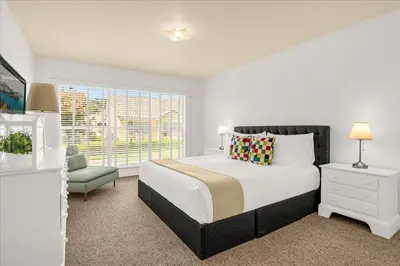 a white bedroom with a large bed and a window at Luxury 4BR Home at Ventura Golf and Country Club in Orlando