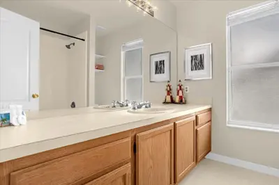 a bathroom with a sink and a large mirror at Luxury 4BR Home at Ventura Golf and Country Club in Orlando