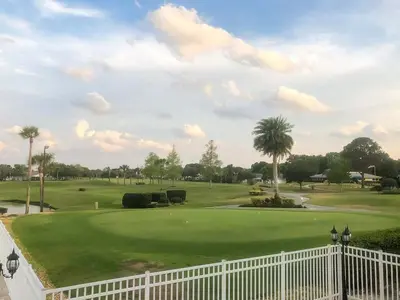 a view of a golf course with a white fence at Luxury 4BR Home at Ventura Golf and Country Club in Orlando