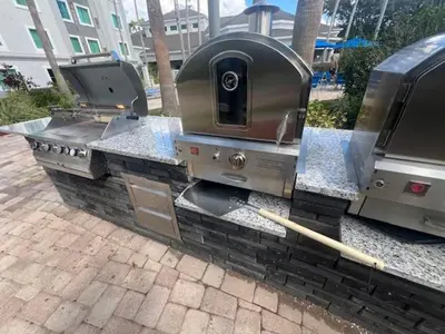 a barbecue grill on a brick walkway with at 5 Minutes to Disney Free Shuttle King & queen bed in Orlando