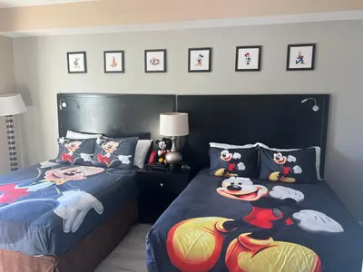 a bedroom with two beds with cartoon characters on them at 5 Minutes to Disney Free Shuttle King & queen bed in Orlando