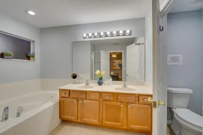 a bathroom with a sink and a tub and a toilet at Kissimmee Oasis with Resort Perks! in Kissimmee