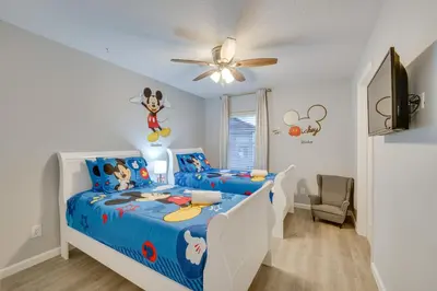 a bedroom with a blue and white bed with a ceiling fan at Kissimmee Oasis with Resort Perks! in Kissimmee