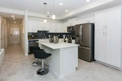 a kitchen with white cabinets and a black refrigerator at Premium Apartment 2BR2BA • Near Disney • PoolLazy River at Storey Lake Resort SL47316 in Kissimmee
