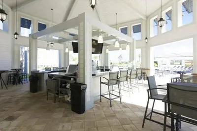 a large room with chairs and a bar with a television at Premium Apartment 2BR2BA • Near Disney • PoolLazy River at Storey Lake Resort SL47316 in Kissimmee