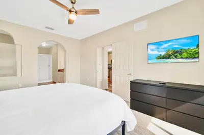 a white bedroom with a bed and a dresser at 3BR Condo - Near Disney Balcony Pool in Orlando