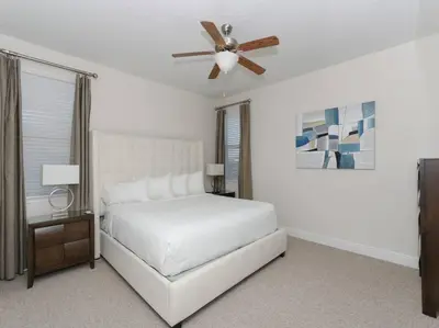 a white bedroom with a bed and a ceiling fan at Luxurious Villa 9br Encore Resort near to Disney in Orlando