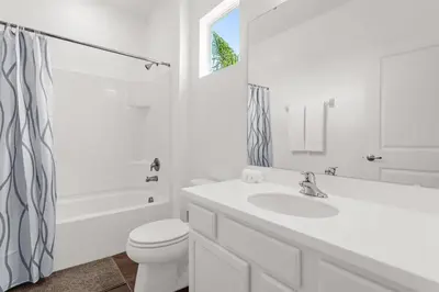 a white bathroom with a sink and a toilet at Upstay Ultimate Orlando Retreat w Pool & Hot Tub Sleeps 16 in Kissimmee