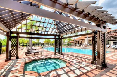 a patio with a swimming pool and a pergola at Upstay Ultimate Orlando Retreat w Pool & Hot Tub Sleeps 16 in Kissimmee