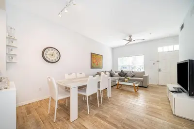 a dining room and living room with a table and chairs at Enchanted Townhome near Disney Parks 3Br in Kissimmee