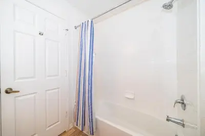a white bathroom with a tub and a shower at Enchanted Townhome near Disney Parks 3Br in Kissimmee