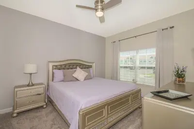 a bedroom with a bed with a ceiling fan and a window at Stunning Townhouses 5 Minutes away Disney! in Kissimmee