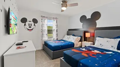 a bedroom with two beds and a desk in it at Stunning Townhouses 5 Minutes away Disney! in Kissimmee