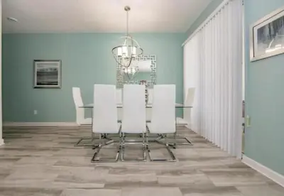 a dining room with a table and white chairs at Stunning Townhouses 5 Minutes away Disney! in Kissimmee