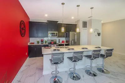 a kitchen with a large island with bar stools at Stunning Townhouses 5 Minutes away Disney! in Kissimmee