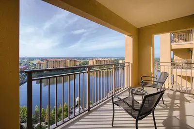 two chairs on a balcony with a view of the water at Bonnet Creek 2 Bedroom Deluxe in Orlando