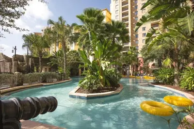 a swimming pool in a resort with palm trees at Bonnet Creek 2 Bedroom Deluxe in Orlando