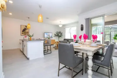a dining room and living room with a table and chairs at Gorgeous 4 Bd w Pool at Storey Lake Resort 2485 in Kissimmee