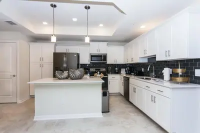 a large kitchen with white cabinets and appliances at Elegant Apartment 3BR2BA • Near Disney • PoolLazy River at Storey Lake Resort SL47318 in Kissimmee