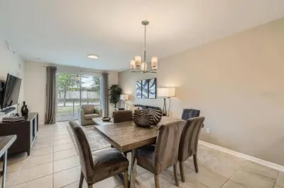 a dining room and living room with a table and chairs at Luxurious Apartment 2BR2BA • Near Disney • PoolLazy River at Storey Lake Resort SL47315 in Kissimmee
