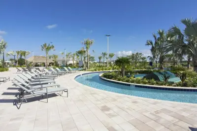 a pool at a resort with lounge chairs and palm trees at Luxurious Apartment 2BR2BA • Near Disney • PoolLazy River at Storey Lake Resort SL47315 in Kissimmee