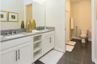 a bathroom with two sinks and a toilet at Exceptional Apartment 4BR3BA • Near Disney • PoolLazy River at Storey Lake Resort SL47512 in Kissimmee