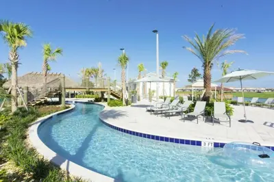 a pool with chairs and umbrellas at a resort at Exceptional Apartment 4BR3BA • Near Disney • PoolLazy River at Storey Lake Resort SL47512 in Kissimmee