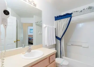 a bathroom with a sink and a toilet and a mirror at Emerald Island Kissimmee in Kissimmee