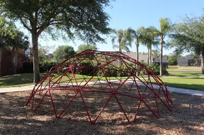 a red metal structure sitting in a park at Emerald Island Kissimmee in Kissimmee