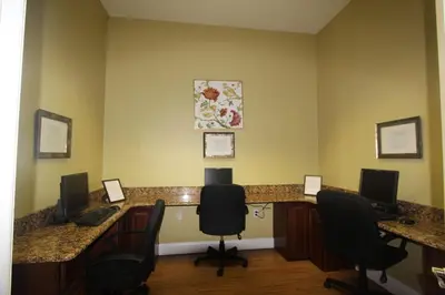 an office with two desks with computers and chairs at Emerald Island Kissimmee in Kissimmee