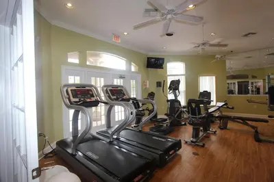 a gym with several tread machines in a room at Emerald Island Kissimmee in Kissimmee