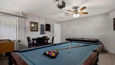 a living room with a pool table and a ceiling fan at Tranquil Formosa Gardens Villa in Orlando
