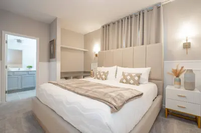 a bedroom with a large white bed and a bathroom at Brand New Top Elegance Home at Paradiso 6086 in Orlando