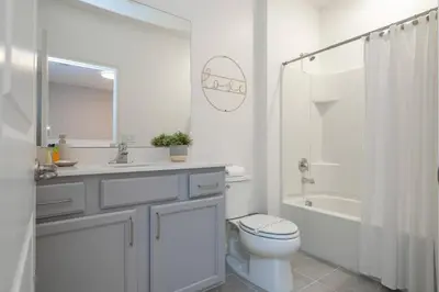 a white bathroom with a toilet and a sink and a shower at Brand New Top Elegance Home at Paradiso 6086 in Orlando