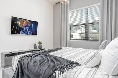 a bedroom with a bed and a tv on the wall at Brand New Top Elegance Home at Paradiso 6086 in Orlando