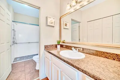 a bathroom with a sink and a toilet and a mirror at Near Disney - 2BR Condo - Balcony Pool in Orlando