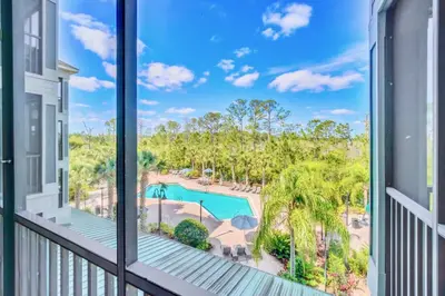 a balcony with a view of a pool and palm trees at Near Disney - 2BR Condo - Balcony Pool in Orlando