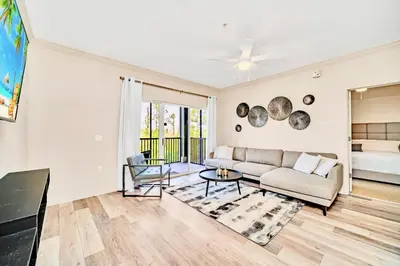 a living room with a couch and a table at Near Disney - 2BR Condo - Balcony Pool in Orlando