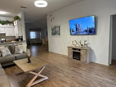a living room with a couch and a tv on the wall at Private pool with a beautiful view overlooking the lake! Near Disney - Universal in Kissimmee