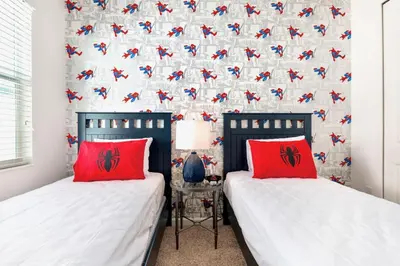 two beds with red pillows in a bedroom at Family-Friendly Mansion at Sonoma Luxury Resort in Kissimmee