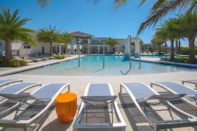 a pool with chaise lounge chairs and a table at Family-Friendly Mansion at Sonoma Luxury Resort in Kissimmee